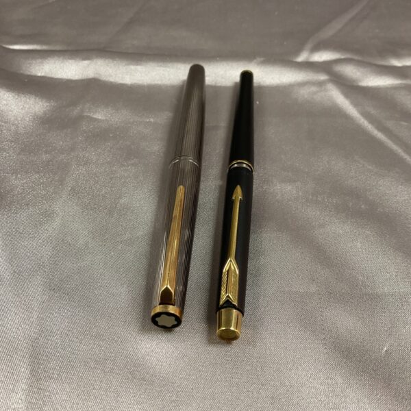 Vintage Montblanc and Parker fountain pens on satin background.