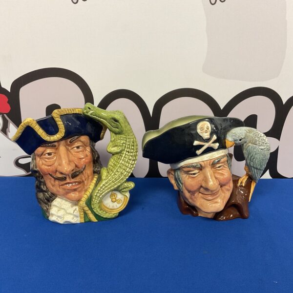 Royal Doulton character jugs depicting Captain Hook and Long John Silver.