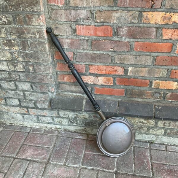 Antique copper bed pan with dark handle, vintage medical collectible.