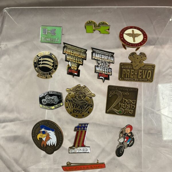 Collection of vintage motorcycle club badges and pins.
