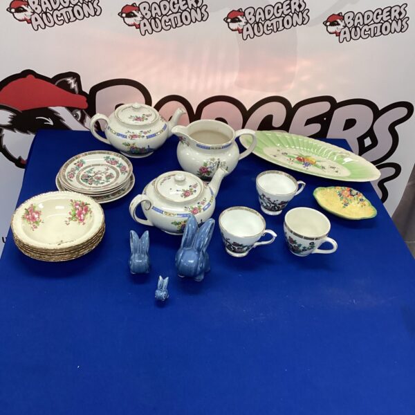 Vintage mixed china tea set with floral patterns on display.
