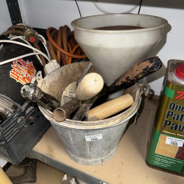 Vintage galvanised buckets and assorted tools in a workshop setting.