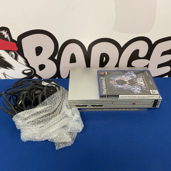 Silver Sony PlayStation 2 console with controller and game.