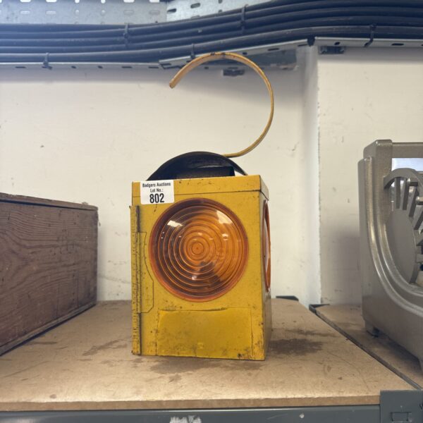 Vintage amber roadside lantern, a collectible traffic signal.