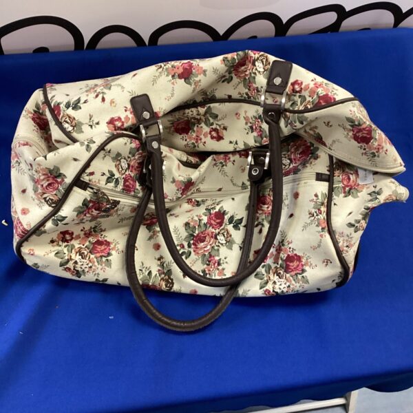 Floral patterned wheeled suitcase for travel and storage.