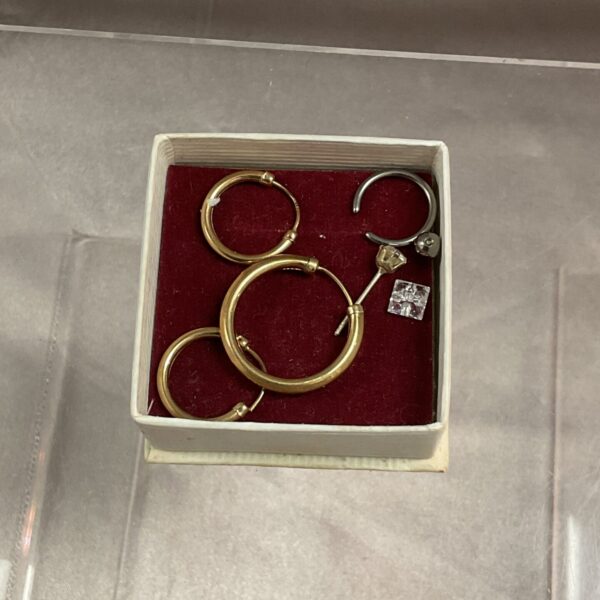 Close-up of a lot of scrap gold hoop earrings.