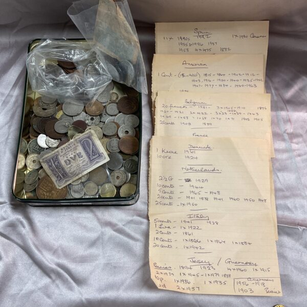 Overview of a tin filled with assorted foreign coins and notes.