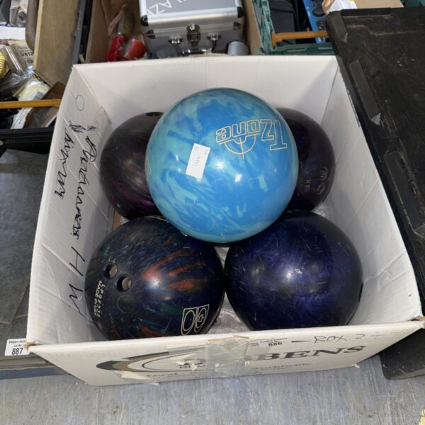 Assorted ten pin bowling balls in a sports equipment lot.