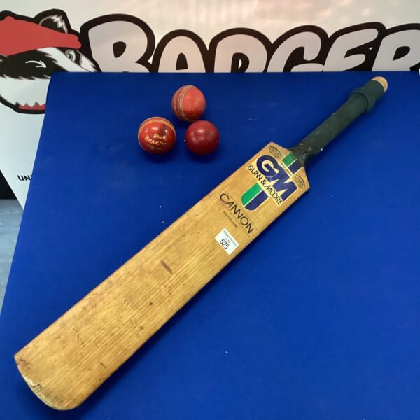 GM cricket bat with three red cricket balls.