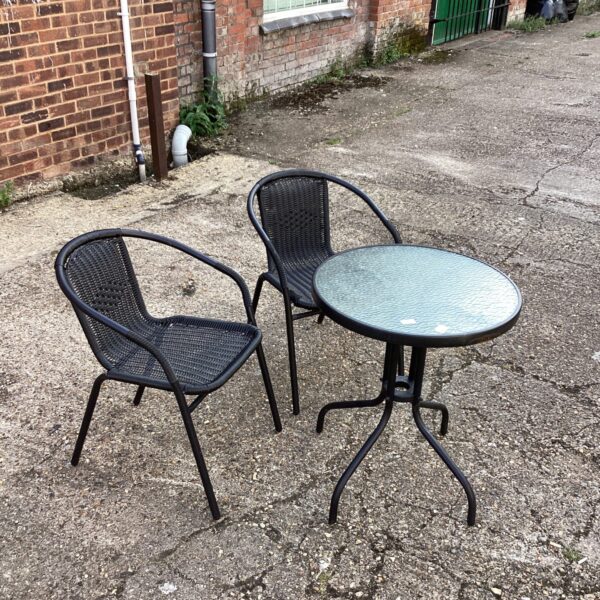 Black metal garden table and chairs set for outdoor dining.