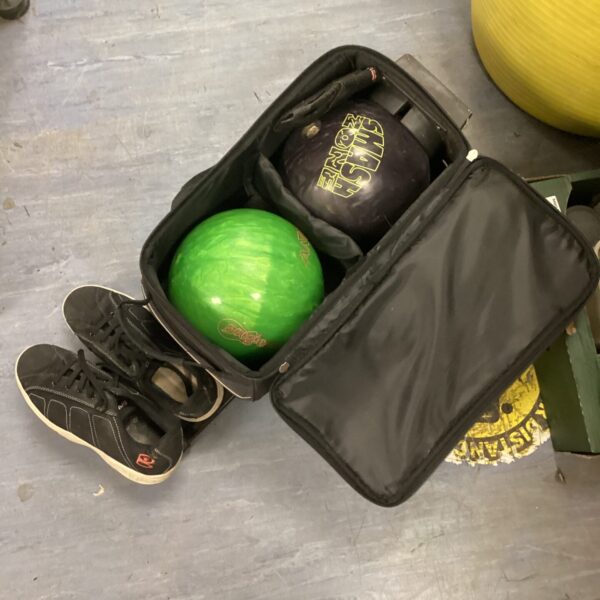 Bowling ball set with shoes and wheeled case for easy transport.
