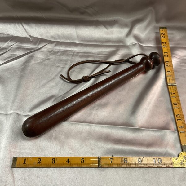 Vintage police truncheon, wooden baton, antique law enforcement equipment.