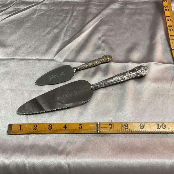 Vintage silver pie and cake server set with ornate handles.