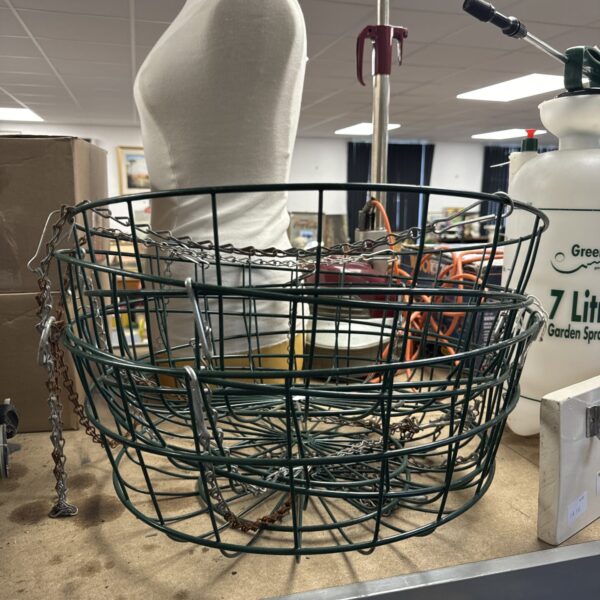 Green metal hanging basket with chain, ideal for garden plants.