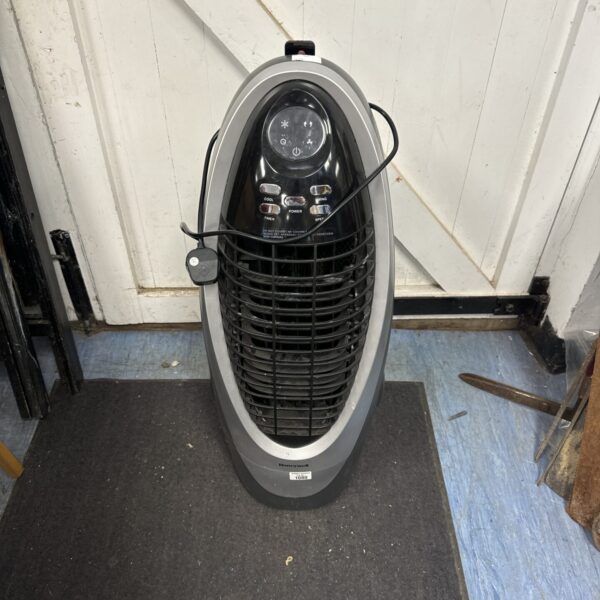 Honeywell tower fan with remote control for cooling a room.