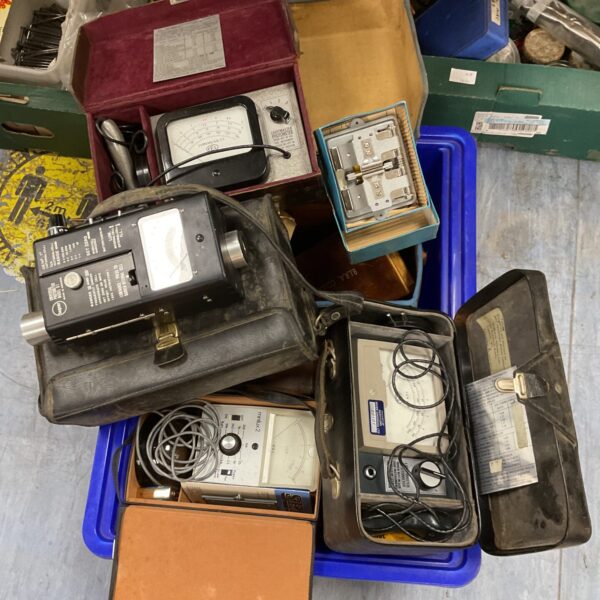 Vintage light meters and film splicer in a crate, collectible photography equipment.