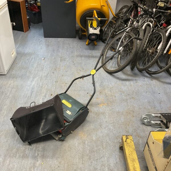 Vintage Webb lawnmower in a garden setting.