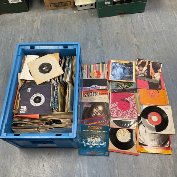 Large crate filled with a diverse collection of 7 inch vinyl records.
