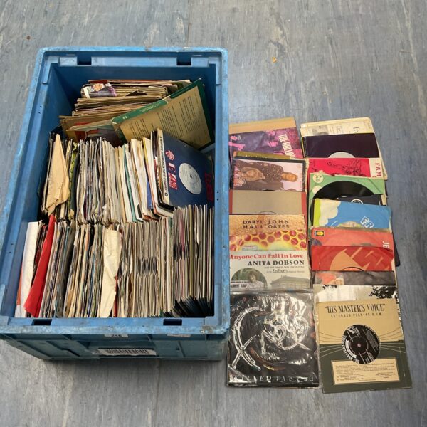 Crate filled with a large lot of vintage 7 inch vinyl records.