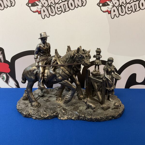 Detailed resin farm scene sculpture with man and chickens.