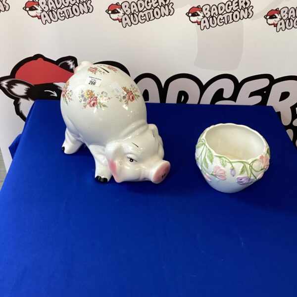 Vintage porcelain piggy bank and vase with floral design.
