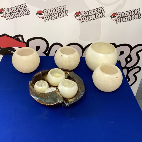 Vintage wax candle holders and decorative bowl set on display.