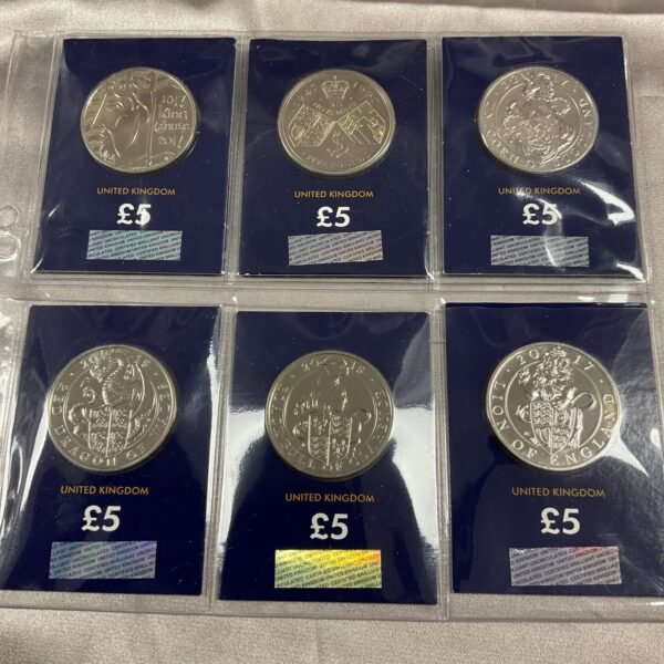 Six £5 Change Checker coins in protective holders, UK commemorative coins.