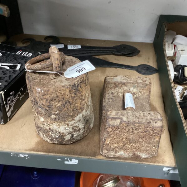 Two antique metal weights with a weathered patina.