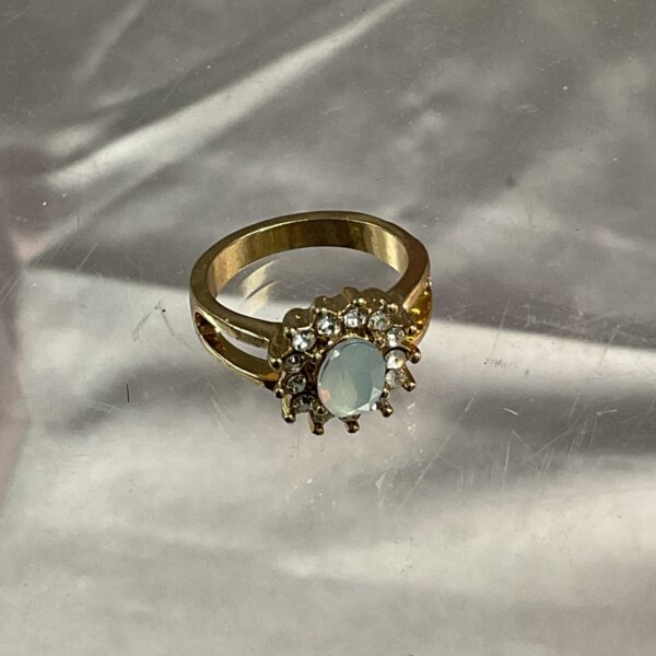 Vintage cluster ring with white stone and yellow metal setting.