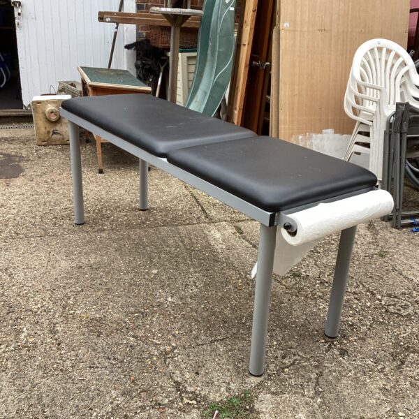 Padded massage table with sturdy metal frame for therapy sessions.