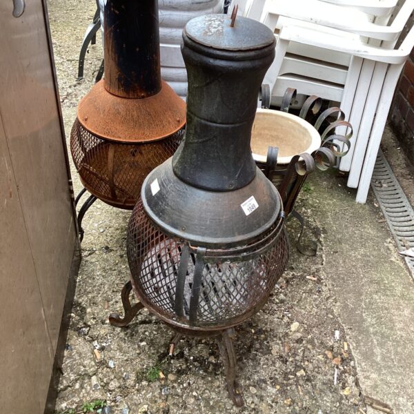 Vintage cast iron garden fire basket with chimney and mesh body.