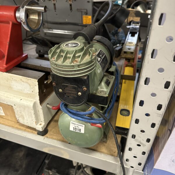 Green Holding CP102 hobby air compressor on a shelf.