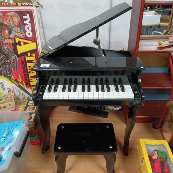 Vintage child's piano with stool, a charming musical toy.