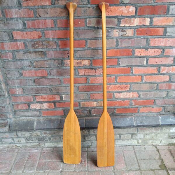 Pair of vintage wooden canoe paddles for boating and collecting.