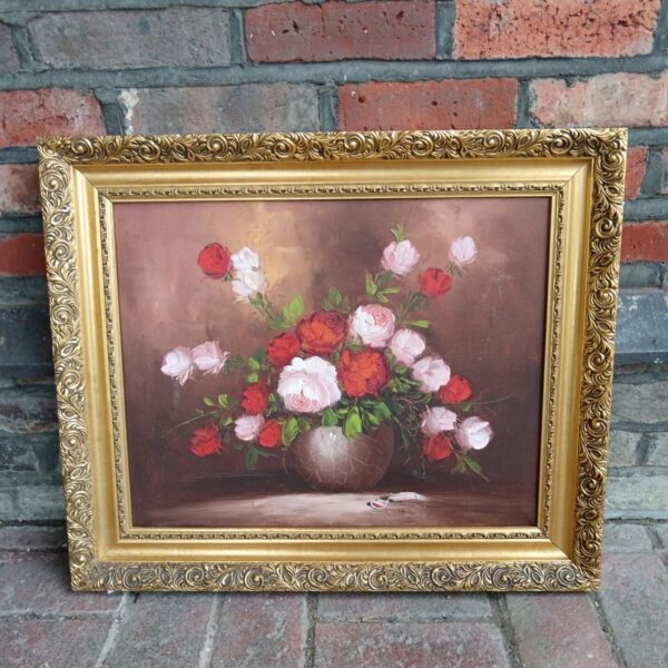 Vintage still life oil painting of roses in a gilt frame.
