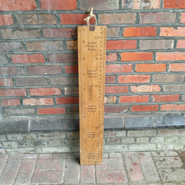 Vintage wooden Hogwarts height chart for tracking magical growth.