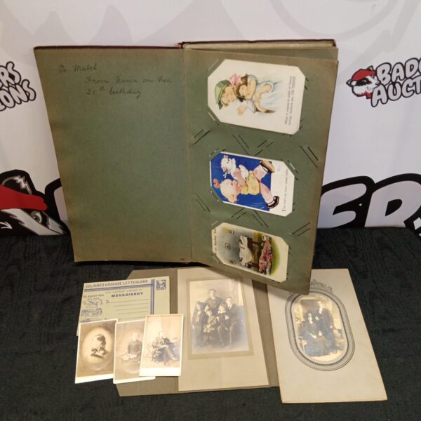 Victorian postcard album with green cover and postcards visible.
