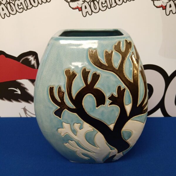 Handmade light blue ceramic vase with tree pattern.