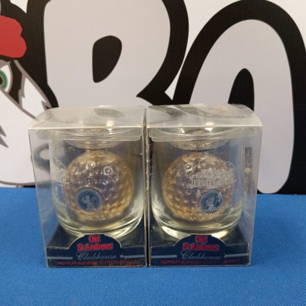 Two St Andrews Clubhouse miniature whiskey decanters in clear cases.