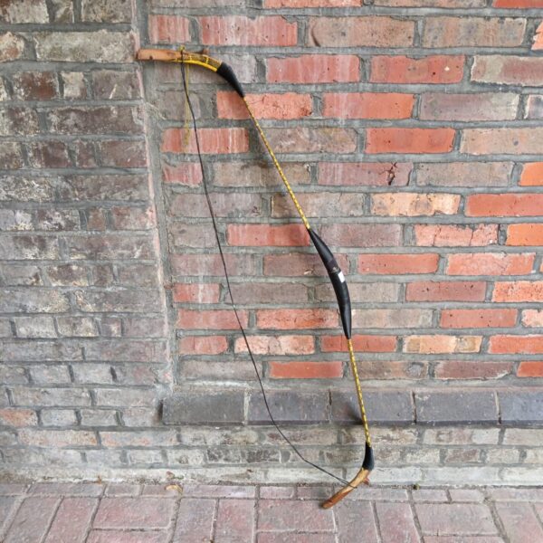 Handmade tribal hunting bow with snake skin detail.