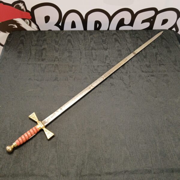 Antique Wilkinson ceremonial sword with etched blade and decorative hilt.