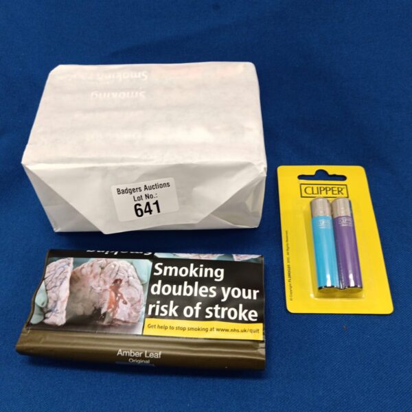 Sealed packs of Amber Leaf tobacco and Clipper lighters in a collectible lot.