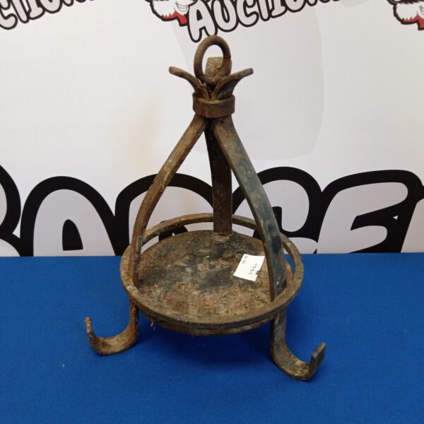 Antique wrought iron candle trivet with curved legs.