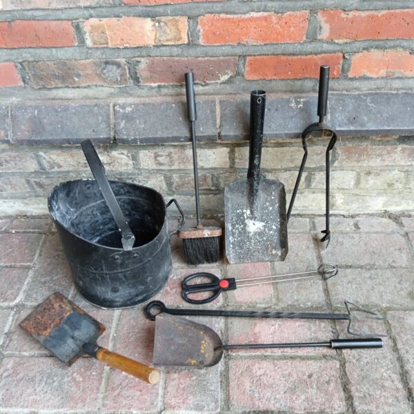 Antique coal bucket and fireplace tools set for a vintage hearth.