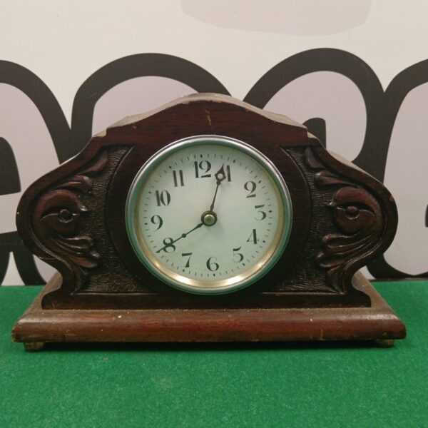 Vintage oak mantle clock with Roman numeral face.