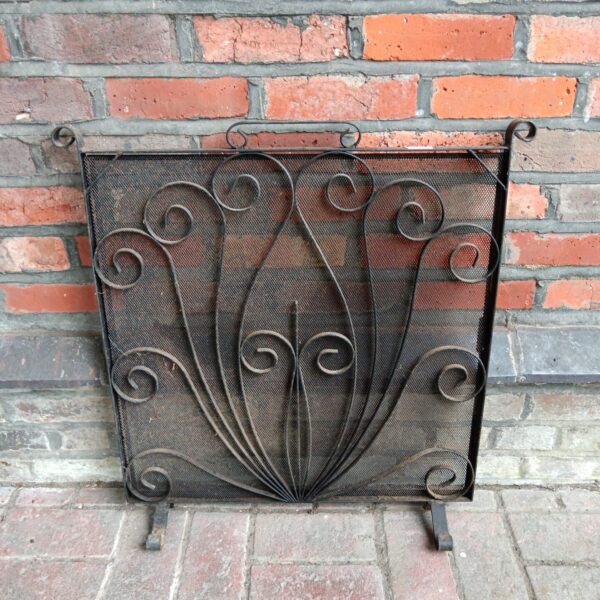 Antique wrought iron firescreen with radiating curved bar design for fireplace.