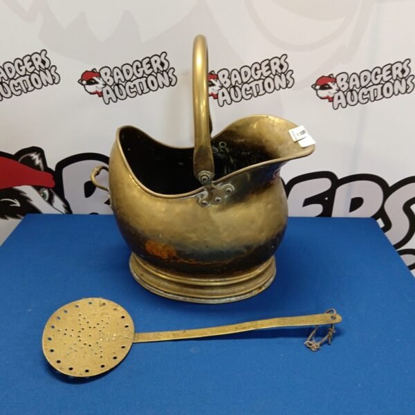 Vintage brass coal scuttle with handle, antique fireplace accessory.