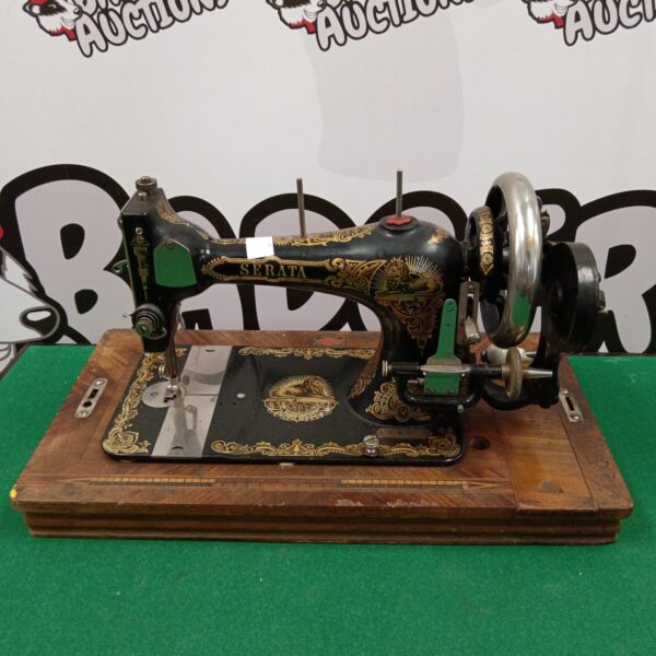 Antique Serata hand crank sewing machine with ornate detailing.