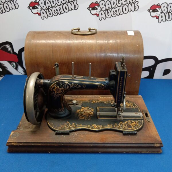 Antique Saxony hand crank sewing machine with ornate detailing.