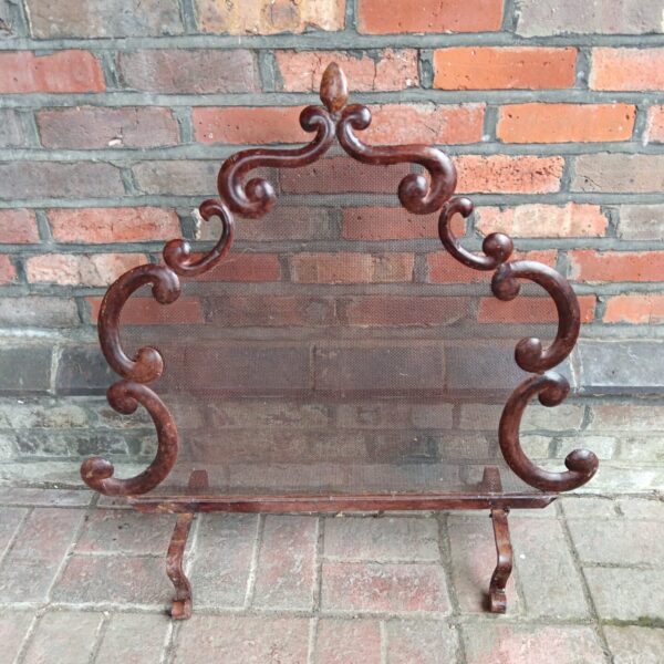 Ornate Art Nouveau metal firescreen with wood effect finish.
